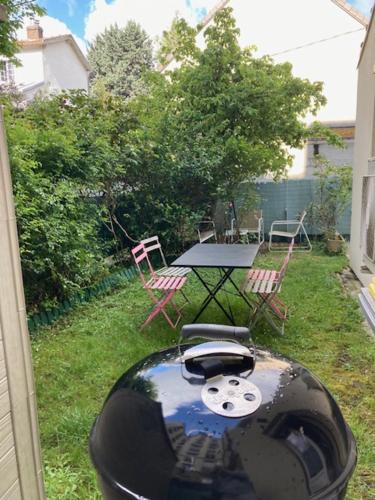 Elle offre une vue sur une arrière-cour dotée d'une table et de chaises. dans l'établissement Maison situé au centre d'Enghien les Bains avec jardin et parking privé, à Enghien-les-Bains