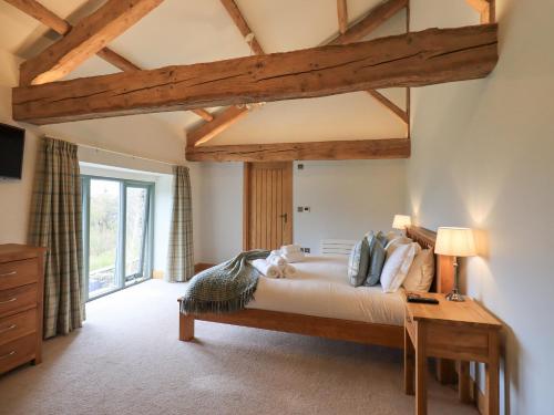 ein Schlafzimmer mit einem großen Bett und einem Schreibtisch in der Unterkunft Keepers Cottage in Ulverston