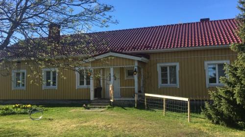 a small yellow house with a red roof at Country house Ruohoranta in Kuopio