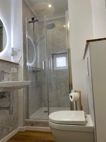 uma casa de banho com um chuveiro, um WC e um lavatório. em Modernes, großes City Appartement 95 qm em Meuselwitz