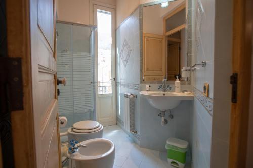 a bathroom with a sink and a toilet and a mirror at Liberty house in Castellammare del Golfo