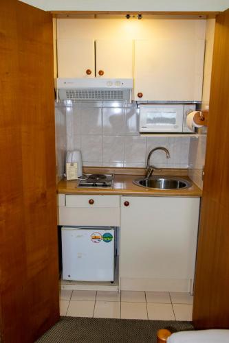 a small kitchen with a sink and a microwave at abba Presidente Suites Puerto Montt in Puerto Montt