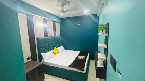 a small room with a bed with a blue wall at HOTEL DBR in Muzaffarpur
