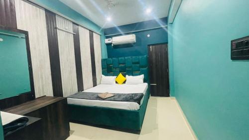 a small bedroom with a bed and blue walls at HOTEL DBR in Muzaffarpur