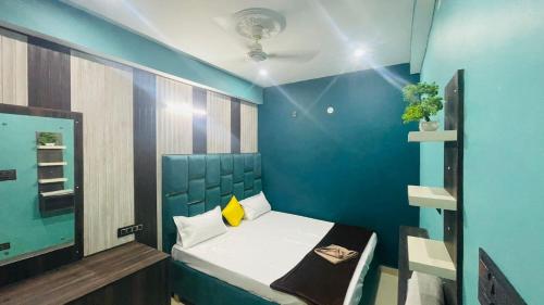 a small room with a bed and a blue wall at HOTEL DBR in Muzaffarpur