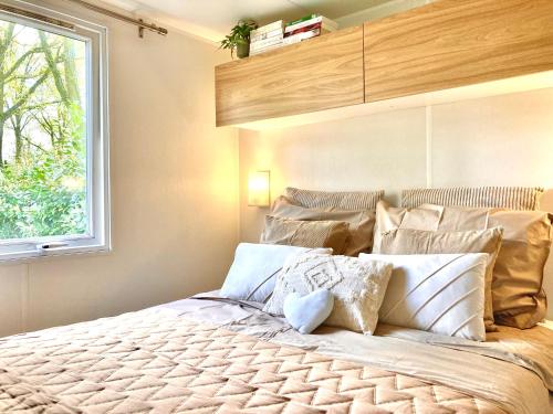 a bedroom with a large bed with a window at Camping de Pallegarste Villa 141 in Mariënberg