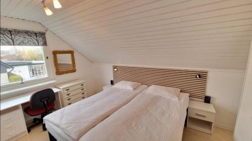 1 dormitorio con cama, escritorio y ventana en Vindsvåning i Simrishamn, en Simrishamn