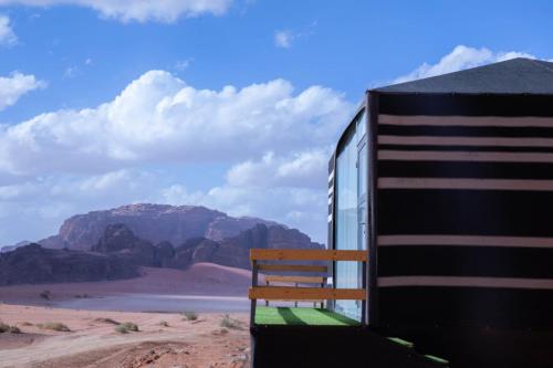 ワディ・ラムにあるDesert Sand Campの砂漠の列車脇に座るベンチ