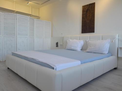 a large white bed in a room with white cabinets at NEBOKRAJ in Kraj