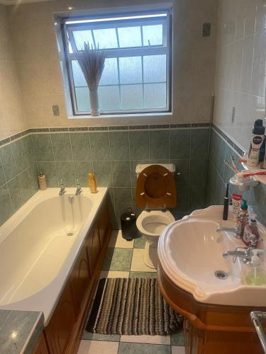 a bathroom with a tub and a toilet and a sink at Tarar’s house in Streatham Hill
