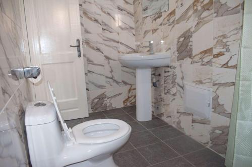 Łazienka z białą toaletą i umywalką w obiekcie Studio Style Moderne w mieście Pointe-Noire