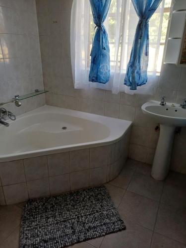 a bathroom with a bath tub and a sink at Serene at 5 on Cologne in Germiston