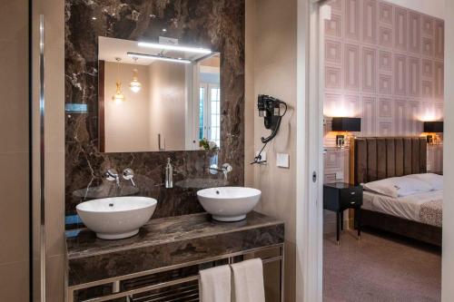 a bathroom with two sinks and a large mirror at Palazzo Bove 2 - Villa Dagmar in Galatone