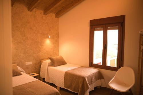 a room with two beds and a window at La Casina de Palacio in Galisteo
