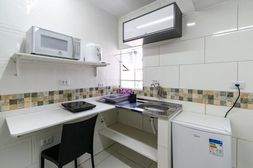 a small kitchen with a sink and a microwave at 57 LOFT QUADRUPLO · LOFT completo perto da São Paulo EXPO in São Paulo
