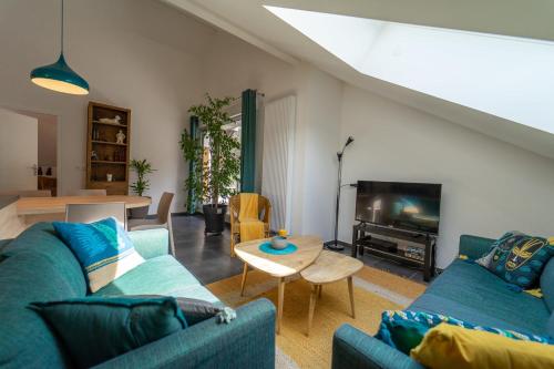 un salon avec deux canapés bleus et une table dans l'établissement La Champanaise - 2 bedroom apartment 300m from Lake Annecy, à Duingt