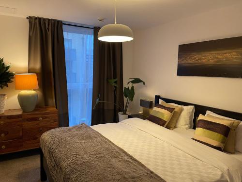 a bedroom with a bed and a lamp and a window at Lombok Apartment near Old Street,Islington,Angel in London