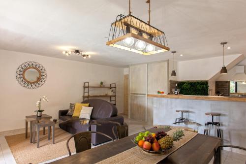 een woonkamer met een tafel met een fruitschaal bij location de vacances figuier avec jardin barbecue piscine chauffée à Calvi in Calvi