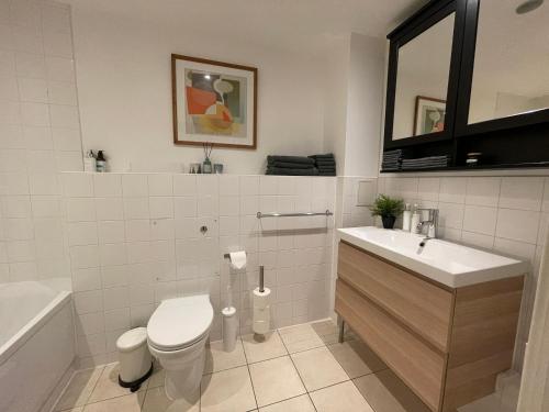 a white bathroom with a toilet and a sink at Lombok Apartment near Old Street,Islington,Angel in London