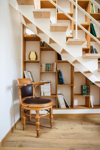 une chaise assise devant une étagère dans l'établissement Le Chant De La Mer - Villerville - Proche Plage, à Villerville