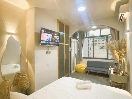 um quarto com uma cama, um sofá e uma televisão em 6EVEN Nguyen Hue em Ho Chi Minh