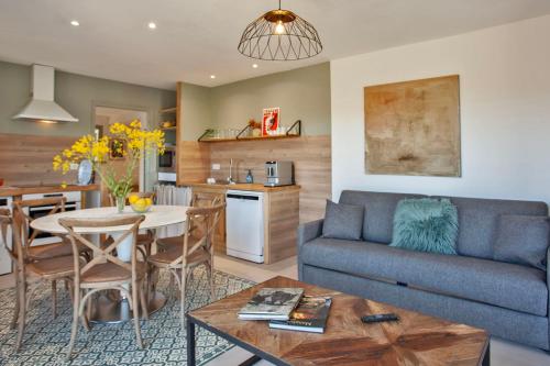 a living room with a couch and a table at location de vacances Olivier jardin privatif et piscine chauffée partagée in Calvi