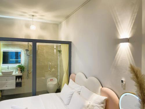 um quarto com uma cama e uma casa de banho com um chuveiro em 6EVEN Nguyen Hue em Ho Chi Minh
