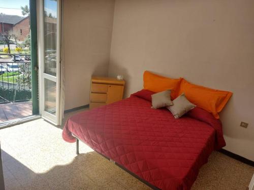 a bedroom with a red bed with an orange comforter at IRIS Bilocale Sant'Anna in Busto Arsizio