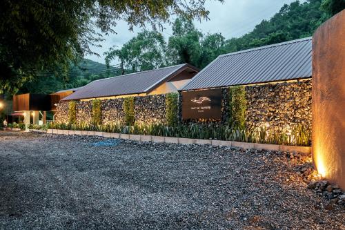 a building with a wall with plants on it at Baan Rai Santisuk in Ban Sok Dua