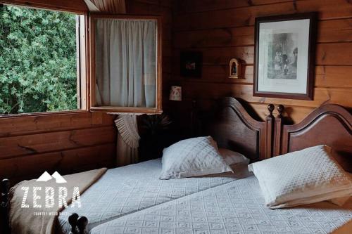 1 dormitorio con cama y ventana en Zebra Country Wood House en Arcos de Valdevez