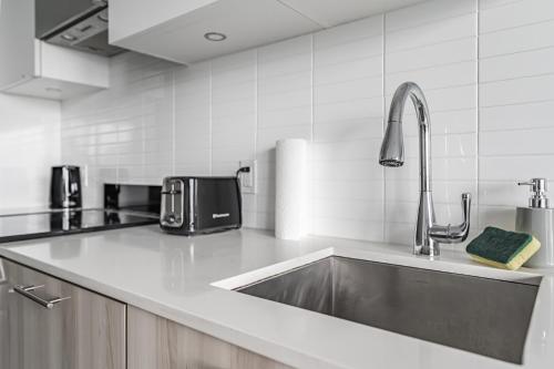a kitchen with a stainless steel sink and a appliance at Jarvis Apartment in Toronto
