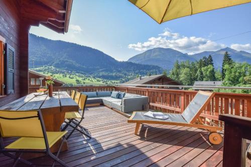 a deck with a couch and a table and chairs at Chalet Castellani Duplex in Fiesch