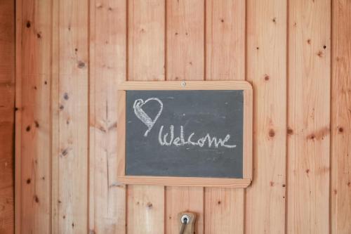 a chalkboard with a heart written on a wooden wall at Chalet Castellani Duplex in Fiesch