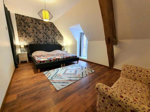 a bedroom with a bed and a chair in a room at Gite de la grange 14 couchages in Saint-Amand-Montrond