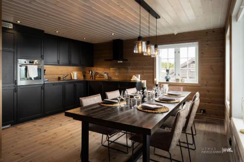 a kitchen with a wooden table with chairs around it at Nesfjellet in Nes i Ådal