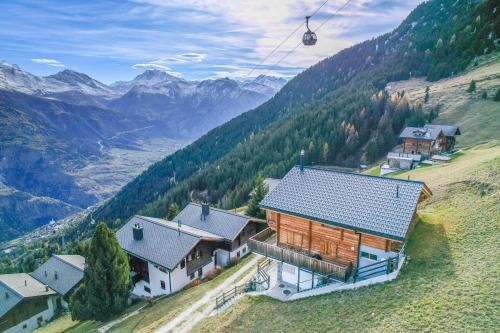 a house on top of a hill with a ski lift at Hirschfluh Duplex in Riederalp