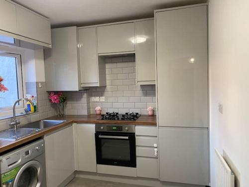 a kitchen with white cabinets and a stove top oven at Brighton NEW Apartment FREE PARKING sleeps 6 in Brighton & Hove