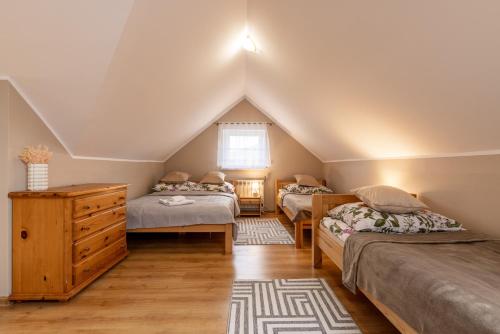 sypialnia na poddaszu z 3 łóżkami i komodą w obiekcie Gościniec Laworta w mieście Ustrzyki Dolne