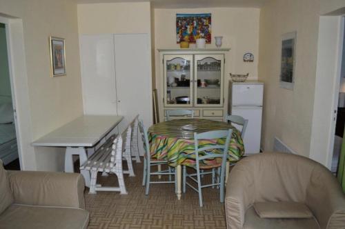 une cuisine avec une table et des chaises dans une pièce dans l'établissement Résidence Le Soulairol - 3 Pièces pour 5 Personnes 24, à Port-Leucate