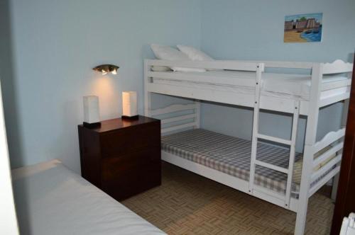 une chambre avec deux lits superposés et une table de chevet avec une lampe dans l'établissement Résidence Le Soulairol - 3 Pièces pour 5 Personnes 24, à Port-Leucate