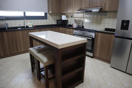 a kitchen with a island in the middle of it at The Coral Villa with marina access, free ka yak and private pool - Al Dana Island Fujairah in Fujairah