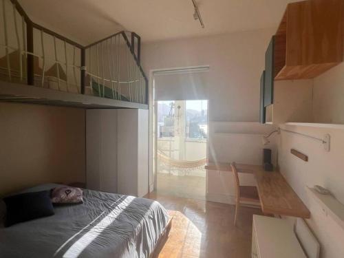 um quarto com uma cama, uma mesa e uma janela em Apto 3q Urca vista Baía e Cristo no Rio de Janeiro