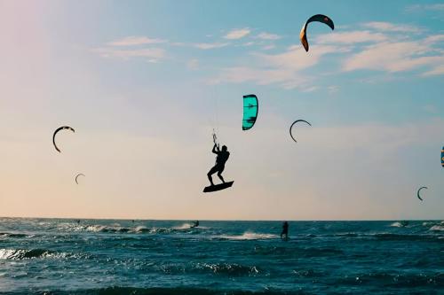 a person riding a surfboard on the ocean with kites at AzulRest Casa de Verano in Juan de Acosta