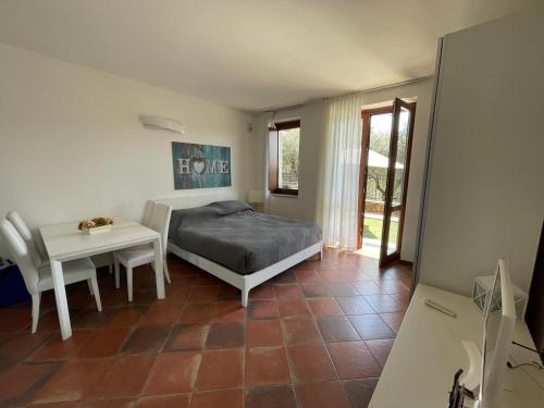 1 dormitorio con 1 cama y 1 mesa en Residence Albatros-Golf & Relax, en Toscolano Maderno
