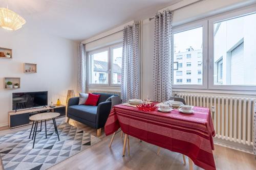 a living room with a table and a couch at Le Clemenceau in Thionville