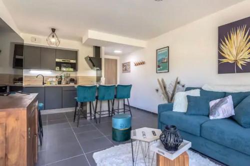 un salon avec un canapé bleu et une cuisine dans l'établissement Le cosy de Duingt charmant appartement à 150m du lac, à Duingt