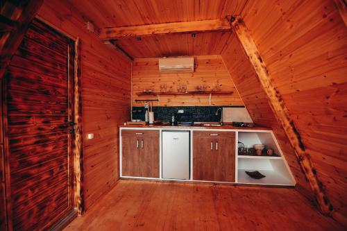 a kitchen in a log cabin with wooden walls at The overlook cottage in Batumi