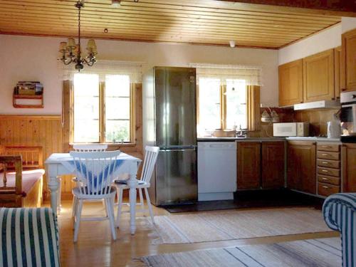 uma cozinha com uma mesa e um frigorífico em Holiday home NORDINGRÅ em Nordingrå