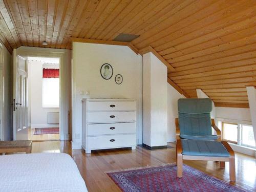 1 dormitorio con cama, silla y vestidor en Holiday home NORDINGRÅ en Nordingrå