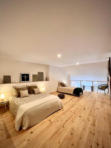 1 Schlafzimmer mit 2 Betten und Holzboden in der Unterkunft La Maison du Cocher in Étival-Clairefontaine
